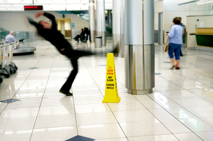 Man slips next to Wet Floor sign